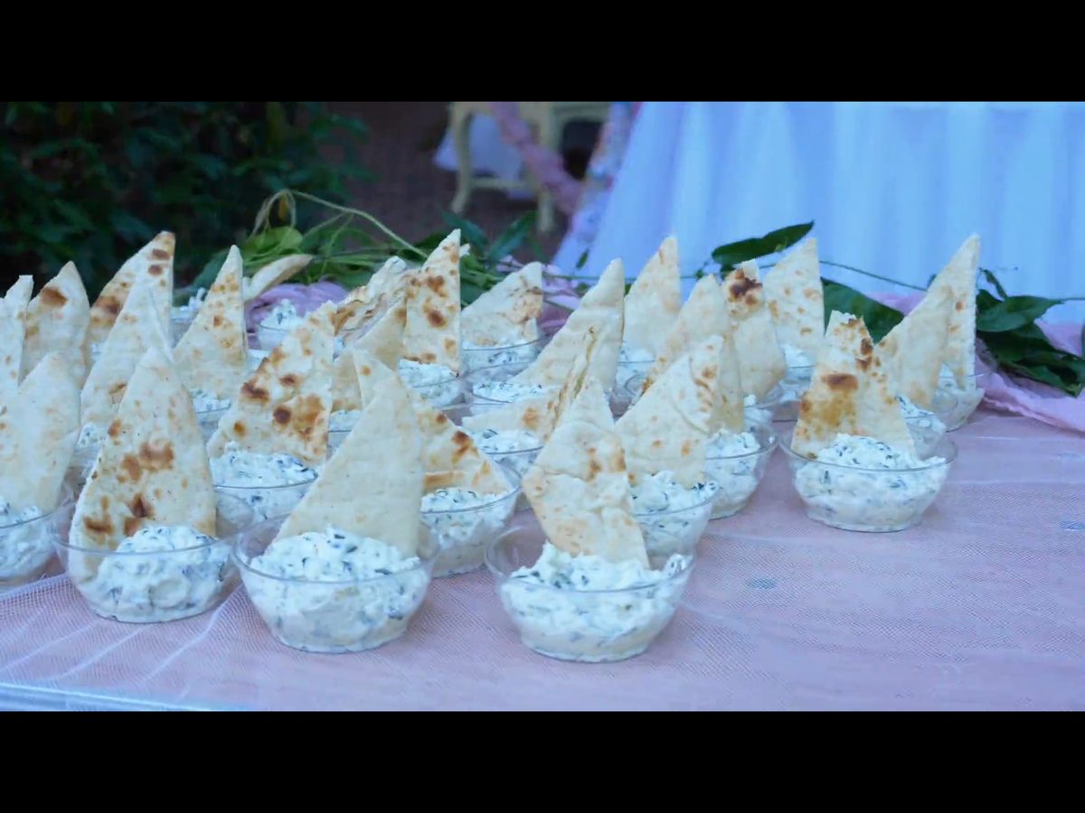 Individually plated appetizers with warm pita, set out on a catering table by ChefsPrep Catering